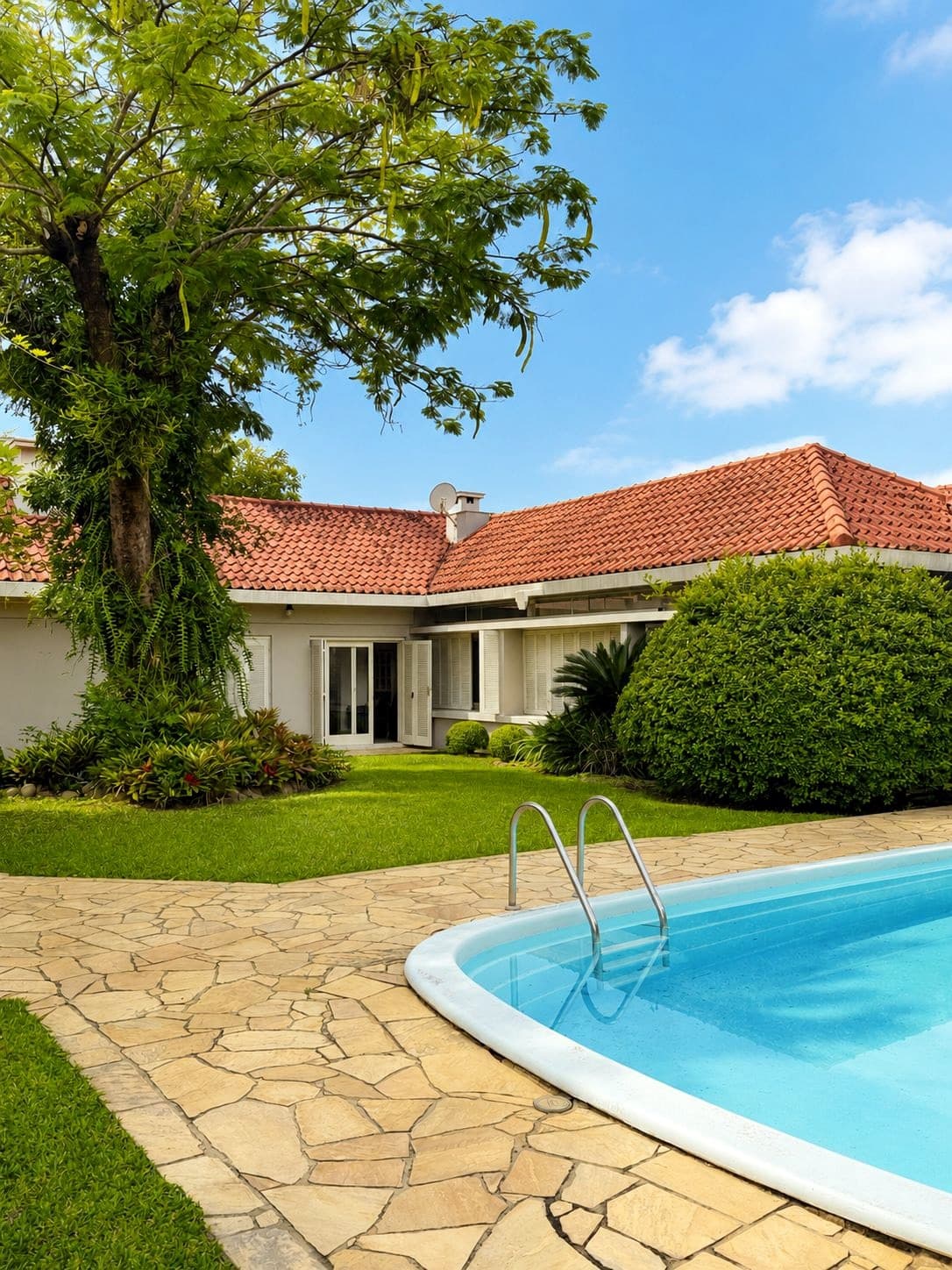 Área externa do Lar Bom Jardim com jardim, casa térrea e piscina