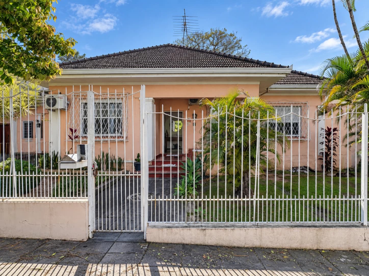 Fachada da Unidade Carlos Gomes, com jardim frontal e portão branco